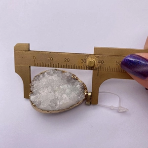 Macro shot of a raw druzy quartz pendant with gold edging showing 35mm width measurement