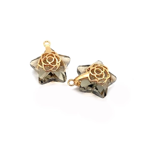 Makro-Detail von sternförmigen Kristallanhängern mit goldenen Rosen-Metall-Filigranen