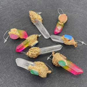 Détail de pendentifs en cristal hexagonal avec bordure dorée et petites pierres colorées