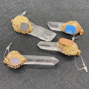 Détail de quatre pendentifs en cristal naturel avec pierres brutes et embouts dorés