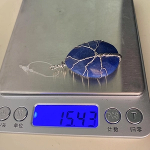 Gedetailleerd overzicht van een blauwe agaat hanger die 15,43 gram weegt op een digitale weegschaal