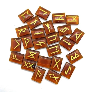 Close-up of translucent amber Rune stones with gold engraved Elder Futhark symbols