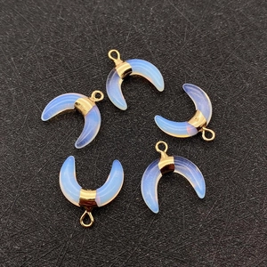 Detailed view of five crescent moon opalite pendants with gold metal caps and bail hooks