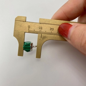 Medición de un colgante de malaquita verde facetada con un calibre de latón