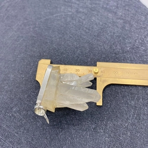 Natural white quartz crystal pendant measured with calipers showing 35mm scale