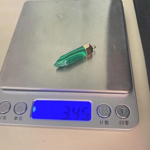 Detailed top view of 3.45g hexagonal malachite pendant on digital scale with gold bail