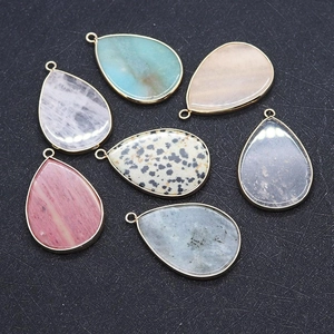 Detail of colorful teardrop gemstone pendants with gold plated edges for DIY jewelry