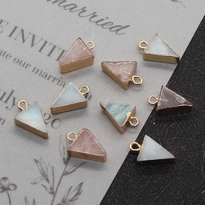 Makroaufnahme bunter dreieckiger Natursteinanhänger mit goldenen Metallrahmen für DIY-Schmuck