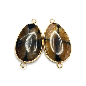 Macro detail of tear-drop imperial stone connectors with gold plated edges for DIY jewelry