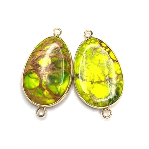 Detail of tear drop shaped natural stone connectors with gold plated frame and double loops