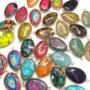 Macro view of colorful oval natural stone connectors with gold plated double loop edges