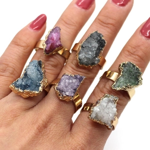 Detail of bohemian gold rings set featuring various colorful raw natural crystal stones