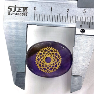 Macro view of purple oval stone with gold chakra symbol measured by caliper, width 25mm