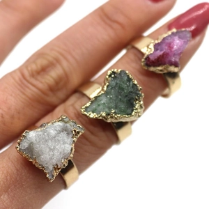 Detailed view of irregular druzy stone rings with gold-plated edges on female hand