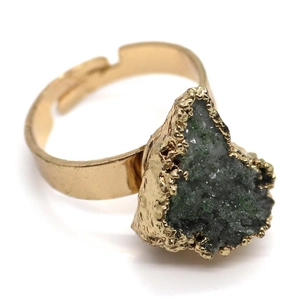 Top view of a gold open ring with an irregular dark green crystal stone and hammered metal