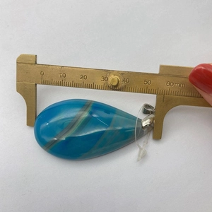 Ciondolo a goccia in agata blu striata misurato con calibro che mostra 50mm di altezza