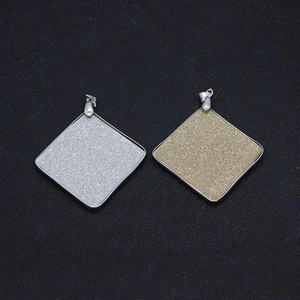 Detail of square shell pendants with gold and silver metal frames for DIY jewelry