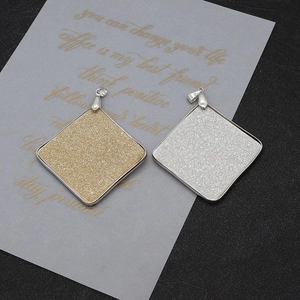 Close-up of square shell glitter pendants with metal frame for DIY jewelry making