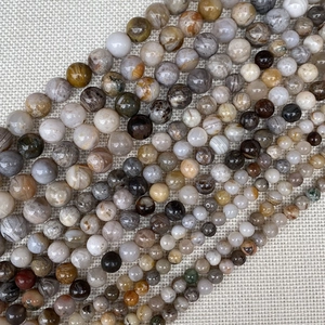 Detailed macro of assorted natural round stone beads for DIY jewelry with polished textures