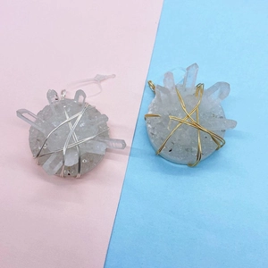Detailed macro view of white crystal cluster pendants wrapped in gold and silver metal wires
