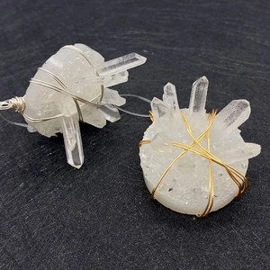 Detail of natural crystal quartz pendants with gold and silver wire-wrapped decoration