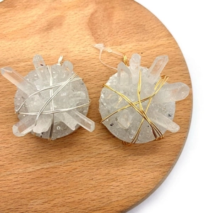 Natural white crystal point pendant with handmade wire wrapping on a wooden display