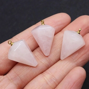 Macro shot of rose quartz pyramid pendants with gold-plated loops held in hand