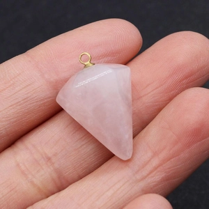 Macro shot of faceted pink quartz crystal pendant with golden metal ring connector