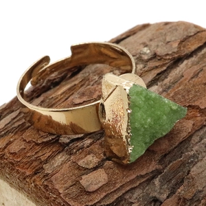Primer plano detallado de una piedra verde triangular en un anillo dorado ajustable