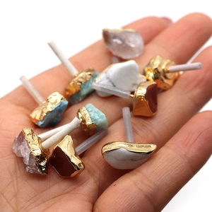 Detailed view of irregular natural raw stone earrings with gold electroplated edges set