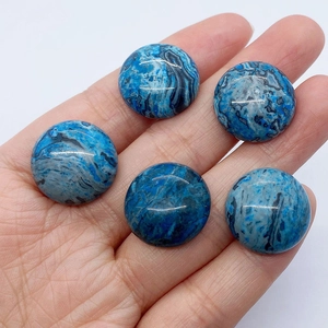Mano che tiene cinque perline cabochon tonde in agata blu crazy lace lucida 19mm