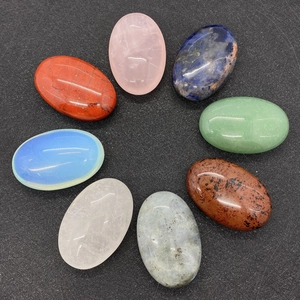 Flat oval polished gemstones set including rose quartz and lapis lazuli in circular layout