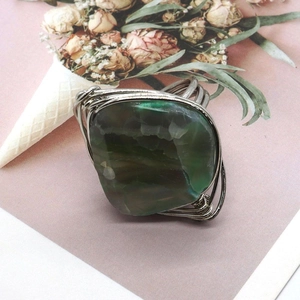 Detail of handmade silver wire wrapped ring featuring a large green irregular agate stone