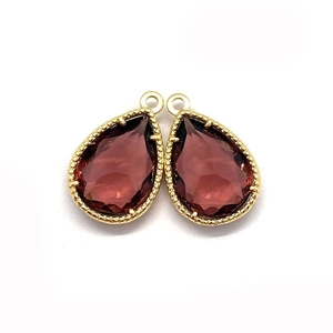 Faceted teardrop crystal pendant in deep red wine stone with a golden milgrain metal frame