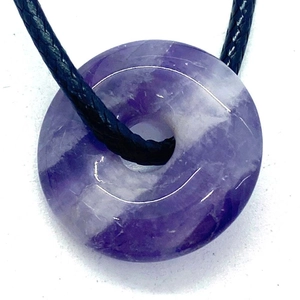 Polished purple amethyst donut pendant with a black woven cord necklace for daily wear