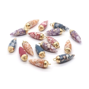 Vue macro de pendentifs en pierre colorée avec calottes dorées pour bijoux DIY