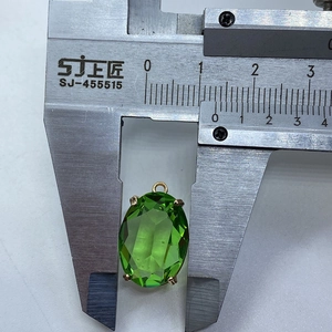 Detailopname van een groene ovale gefacetteerde kristallen hanger met schuifmaat
