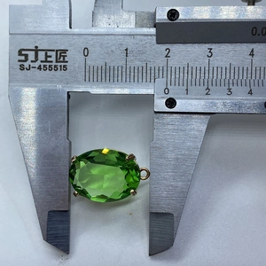 Macro-opname van groene facetgeslepen edelsteen hanger met schuifmaat voor 13x20mm maat