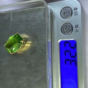 Detail van gefacetteerde groene kristallen hanger op weegschaal met gewicht 3,22 gram