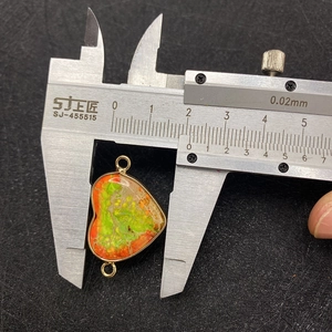 Measuring the 21mm heart-shaped emperor stone connector pendant with a metal caliper