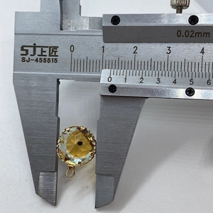 Macro shot showing 12mm amber faceted crystal evil eye pendant with golden bezel measurement
