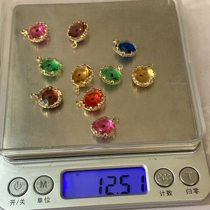 Macro shot of colorful faceted evil eye crystal pendants on a digital scale for size reference