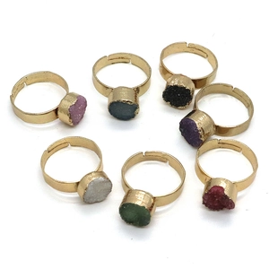 Detailed macro view of seven adjustable gold rings with colorful round druzy crystal stones