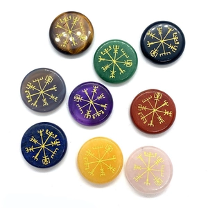 Vista detallada de ocho piedras semipreciosas pulidas con grabados dorados de Vegvisir