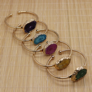 Set de cinco brazaletes de ágata natural con bordes dorados sobre esterilla de bambú