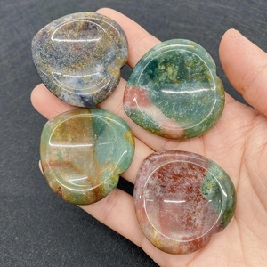 Gros plan de quatre pierres de pouce en forme de cœur polies aux motifs naturels