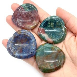 Lot de 4 pierres naturelles en forme de coeur aux textures d'agate colorées dans une main