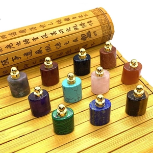 Natural gemstone perfume bottles in various crystals with gold caps on bamboo mat