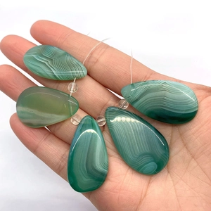 Five natural green striped agate teardrop pendants held in hand for size reference