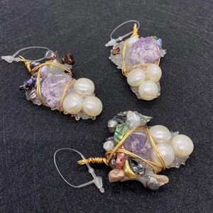 Detailed macro of handmade grape-shaped amethyst and pearl wire-wrapped pendant